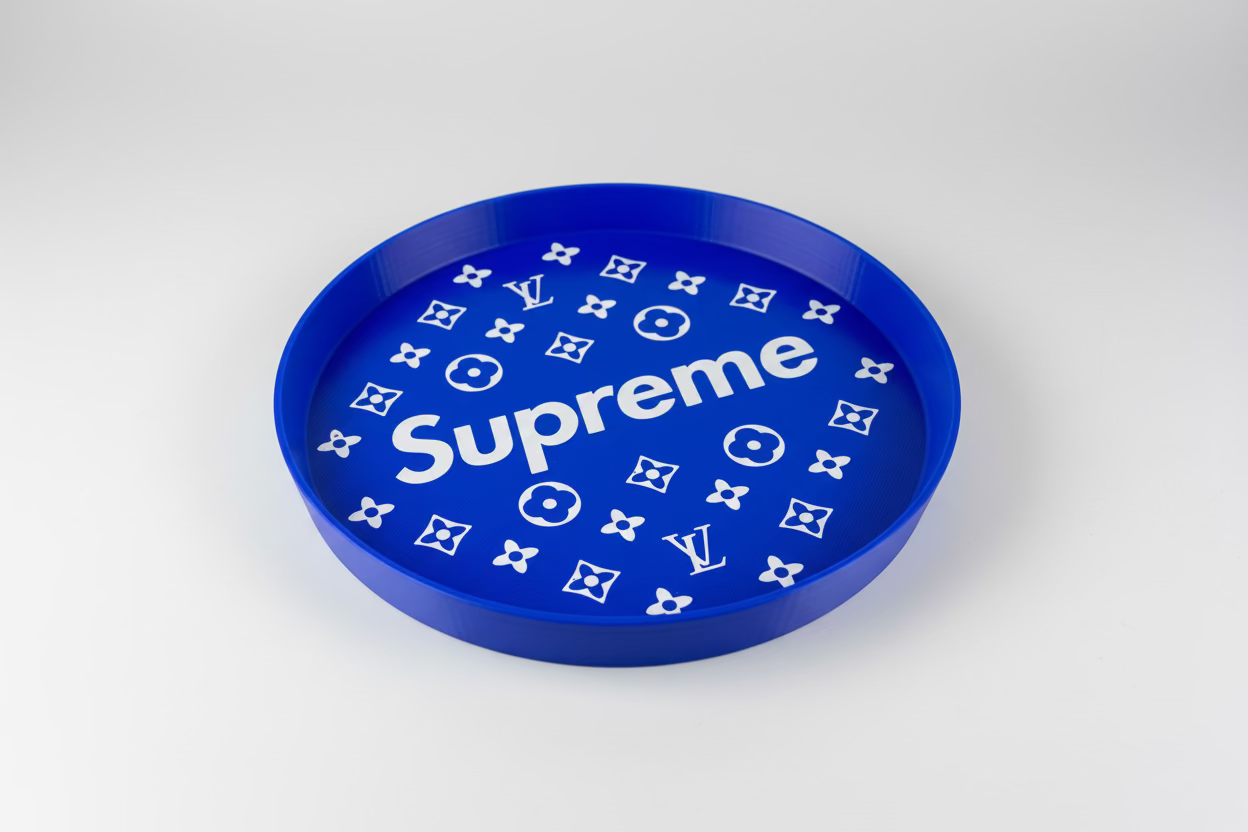Blue circular object with 'Supreme' and Louis Vuitton logos on a gray surface.