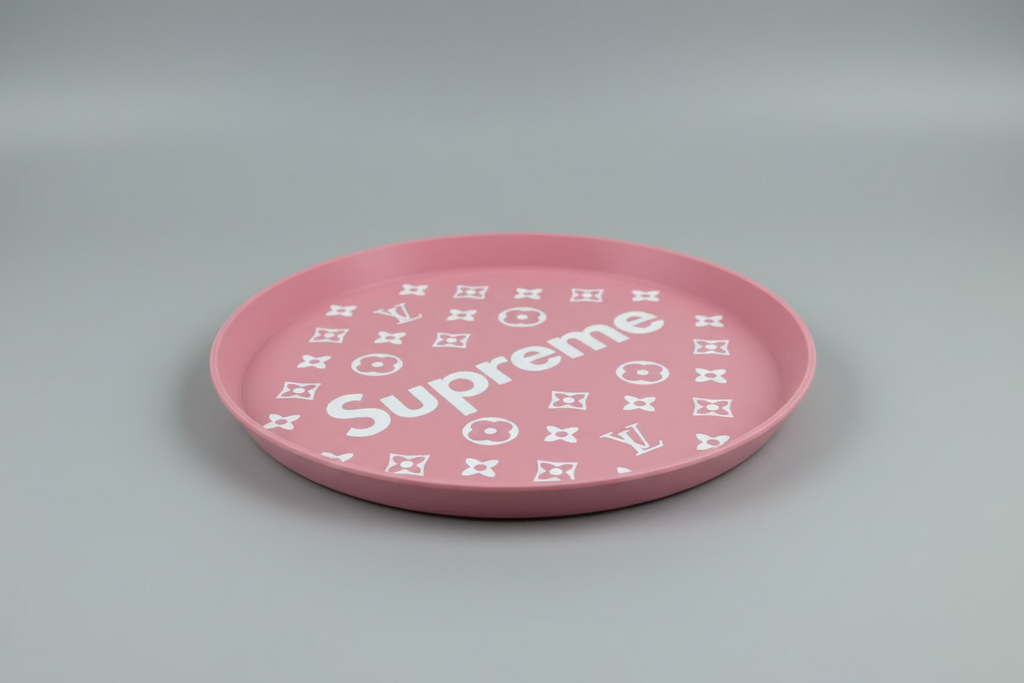Pink plate with 'Supreme' and Louis Vuitton logo on a dark surface