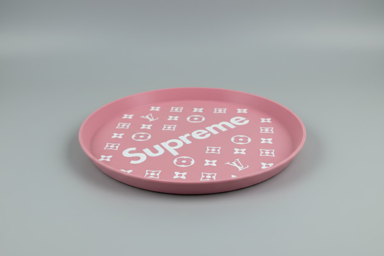 Pink plate with 'Supreme' and Louis Vuitton logo on a dark surface