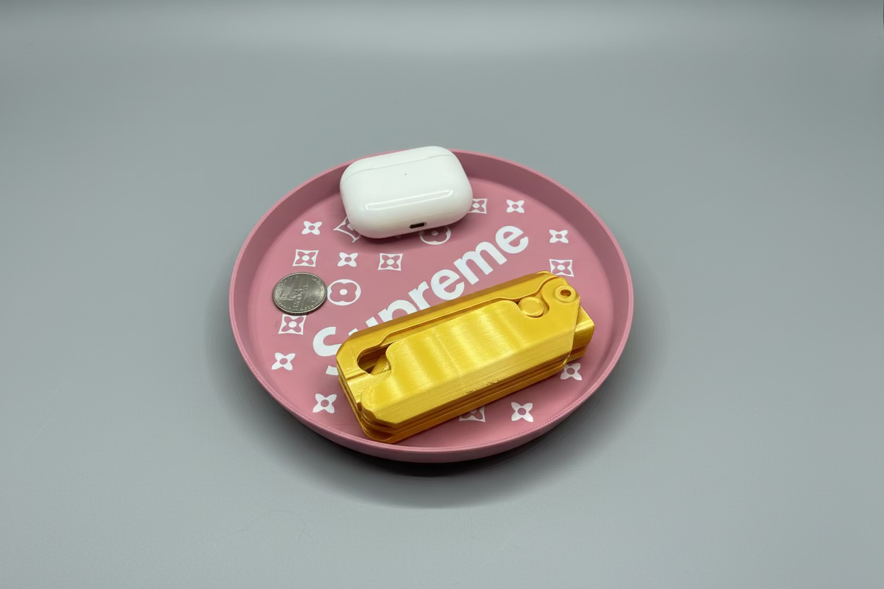 Pink 'Supreme' case with a white device and gold tool on a gray surface.