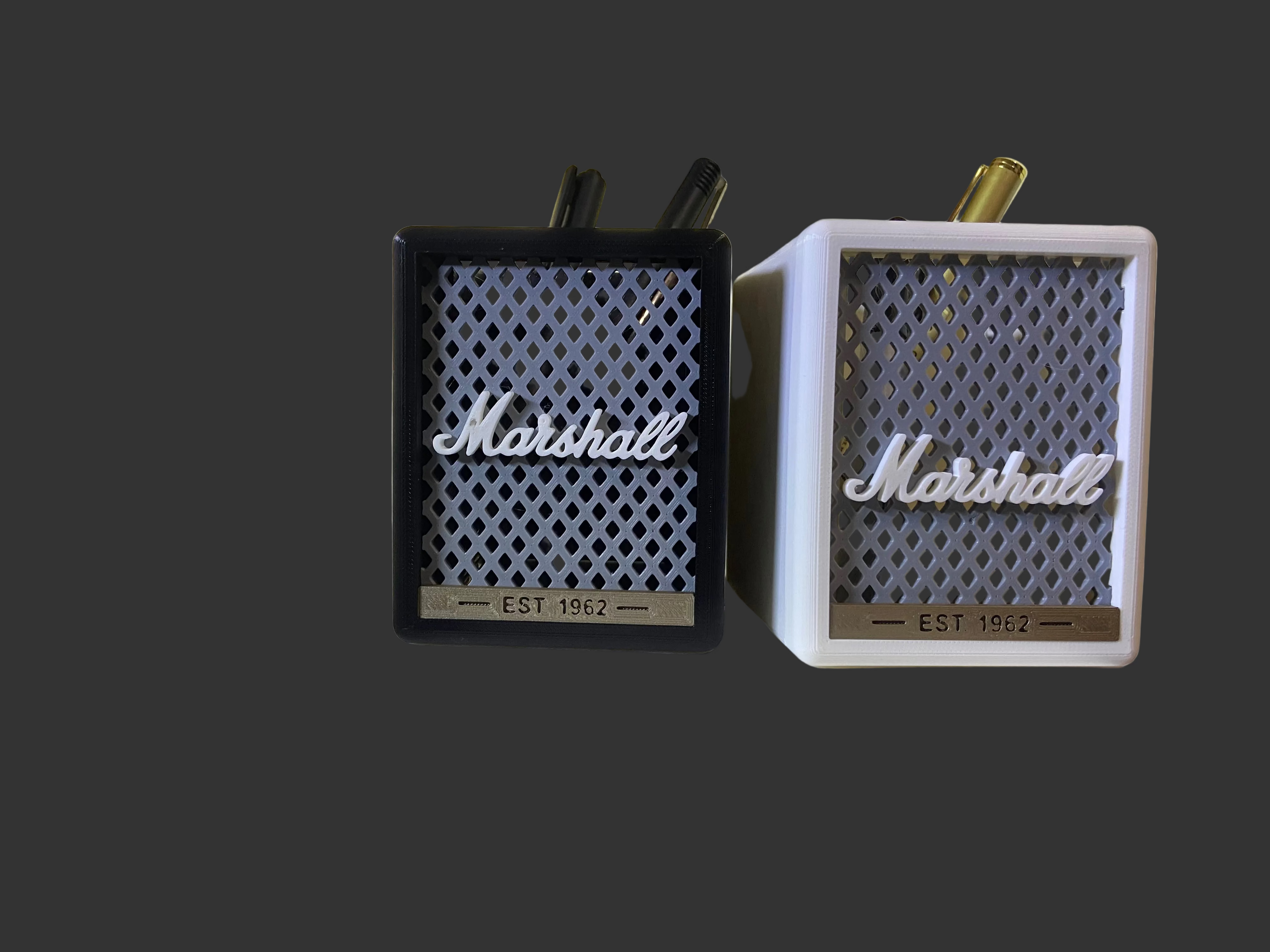 Two Marshall speakers on a white surface with a blurred background