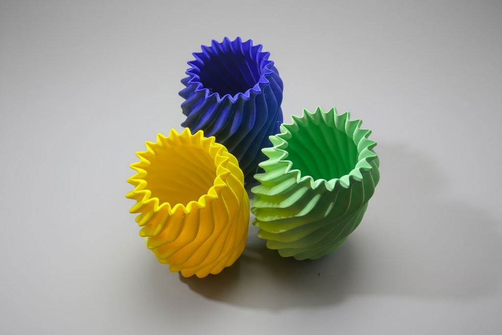 Three colorful silicone cupcake liners on a white surface.