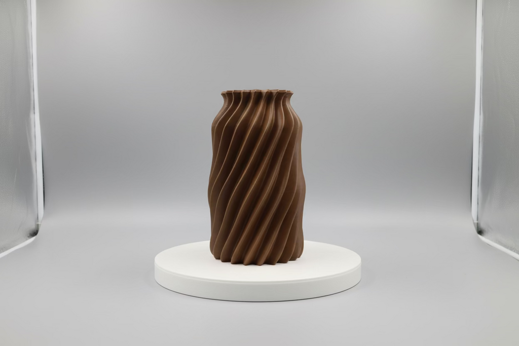 3D printed object on a white platform with a lighted background