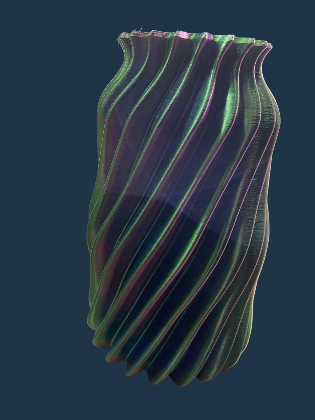 Green and purple striped vase on a white surface