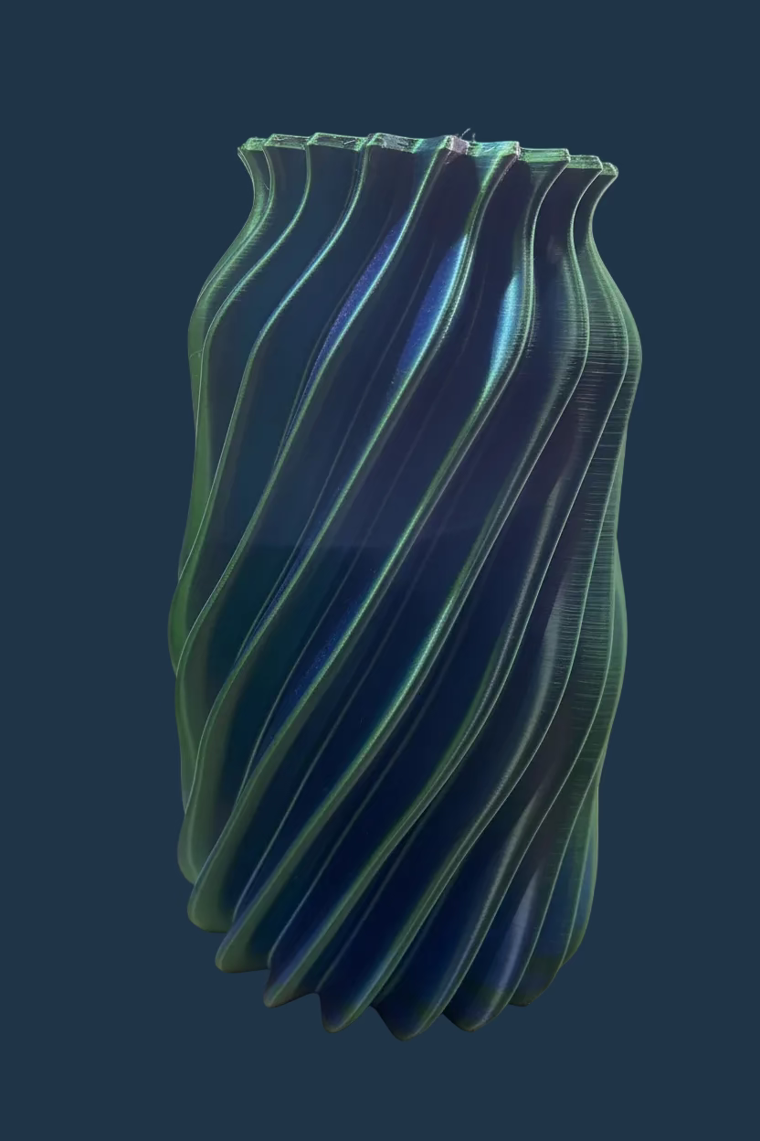 Green glass vase with wavy design on a white surface
