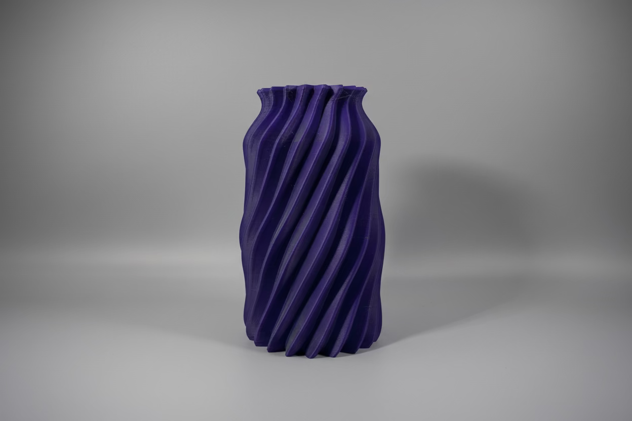 3D-printed purple vase on a white platform with a dark background