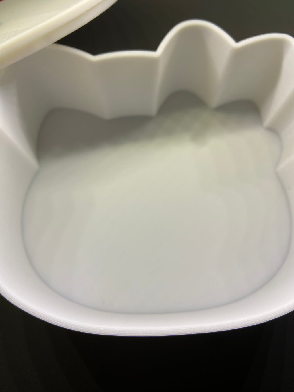 White ceramic bowl with wavy rim on a black background