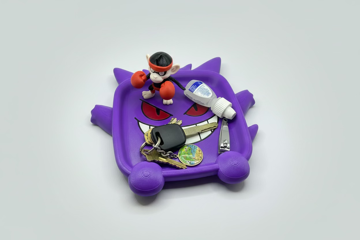 Purple toy car with a character figure, keys, and bottle on a gray surface