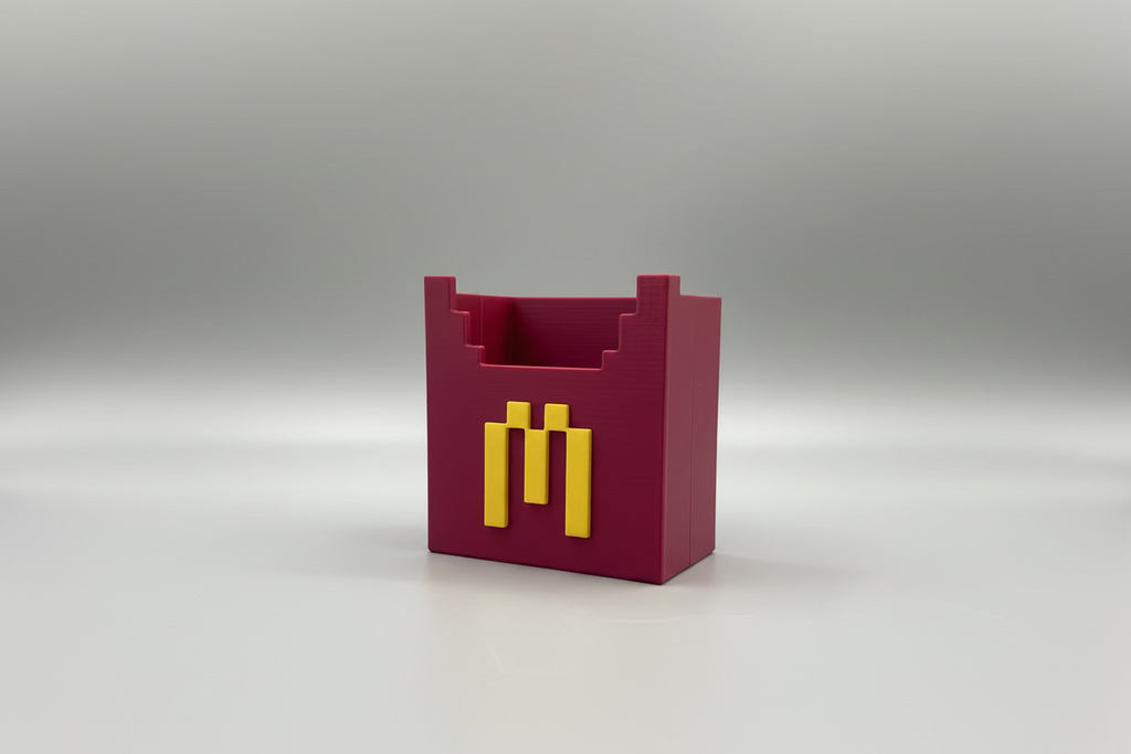 Red and yellow object with a logo on a reflective surface