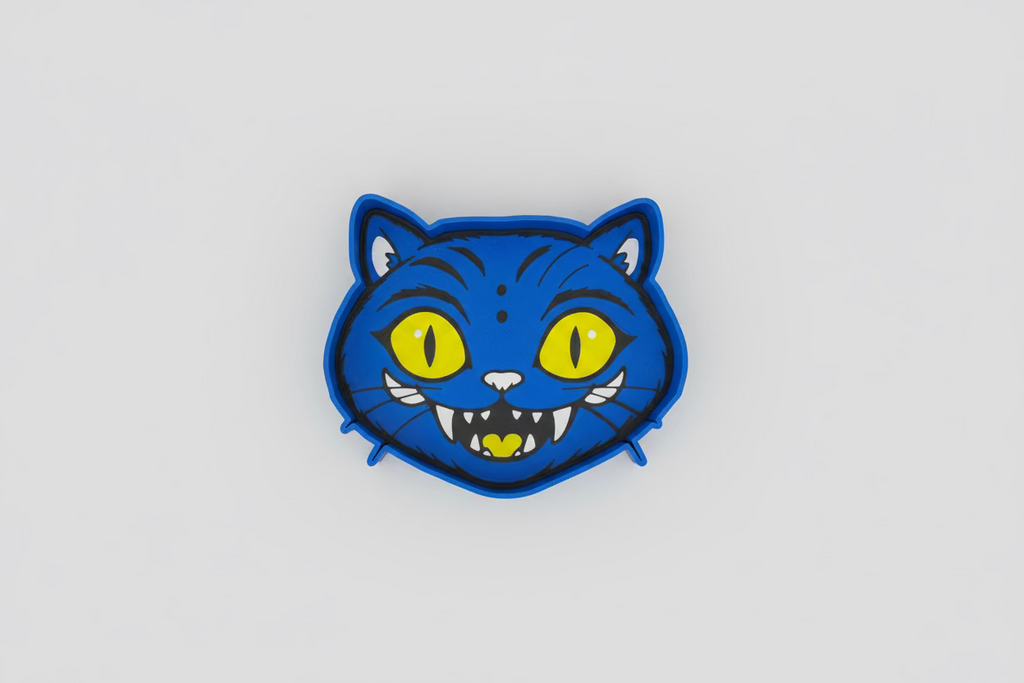 Blue cat-shaped cookie cutter with yellow eyes on a gray background
