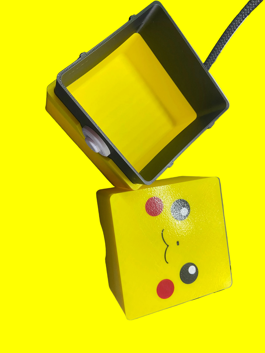 Yellow rectangular box with a cartoon face design on a gray surface